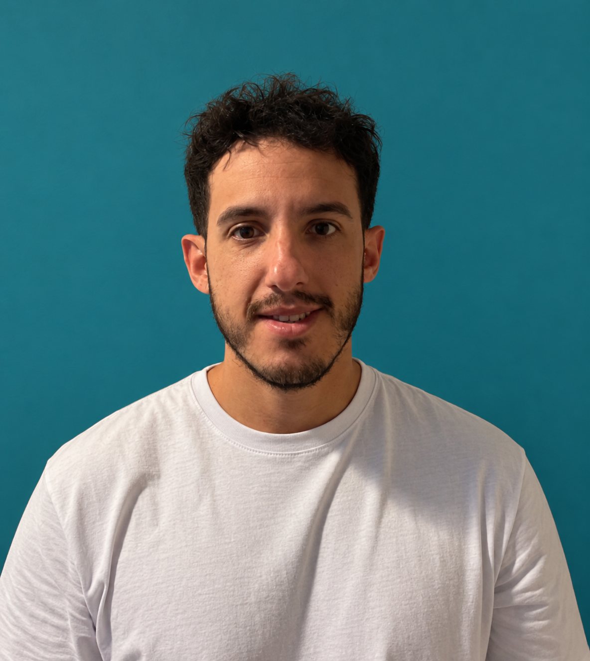 Retrato de Mauricio Illobre con remera blanca sobre fondo azul petróleo
